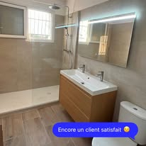 Salle de bain rénovée avec douche à l’italienne, meuble vasque en bois et miroir éclairé